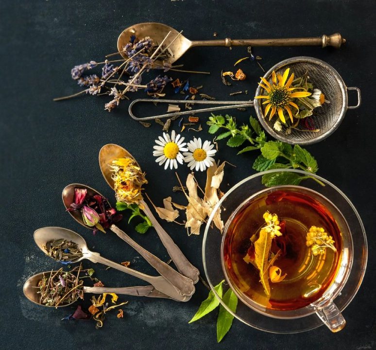 A cup of tea and spoons with flowers on them